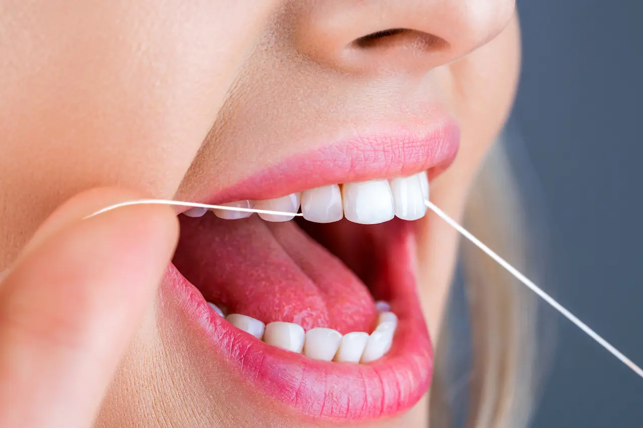 A Woman Flossing Her Teeth