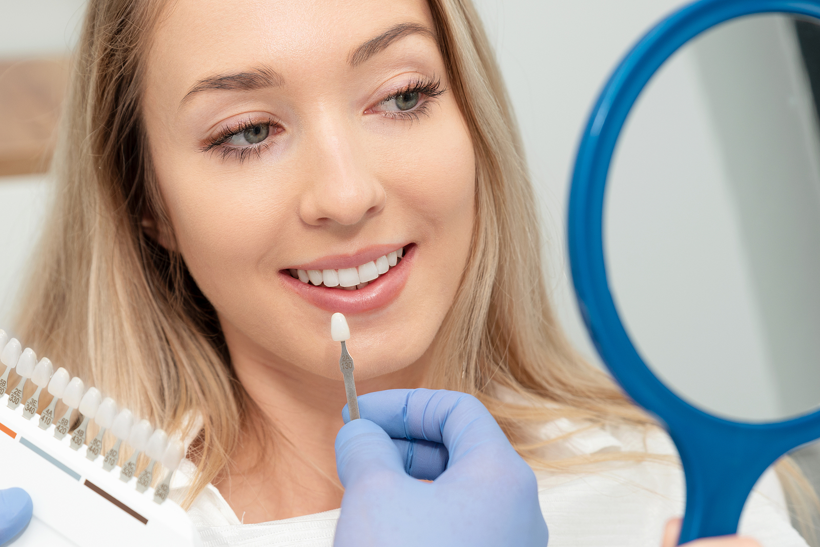 Beautiful Young Woman In Stomatology Clinic. Healthy Teeth White Dental Veneers